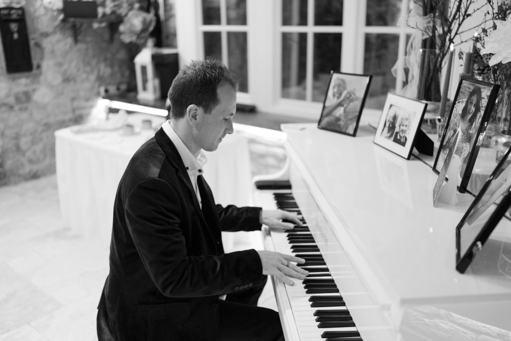 Joe Kenny pianist playing baby grand piano at a wedding drinks receptionn Ballymagarvey Village Co Meath