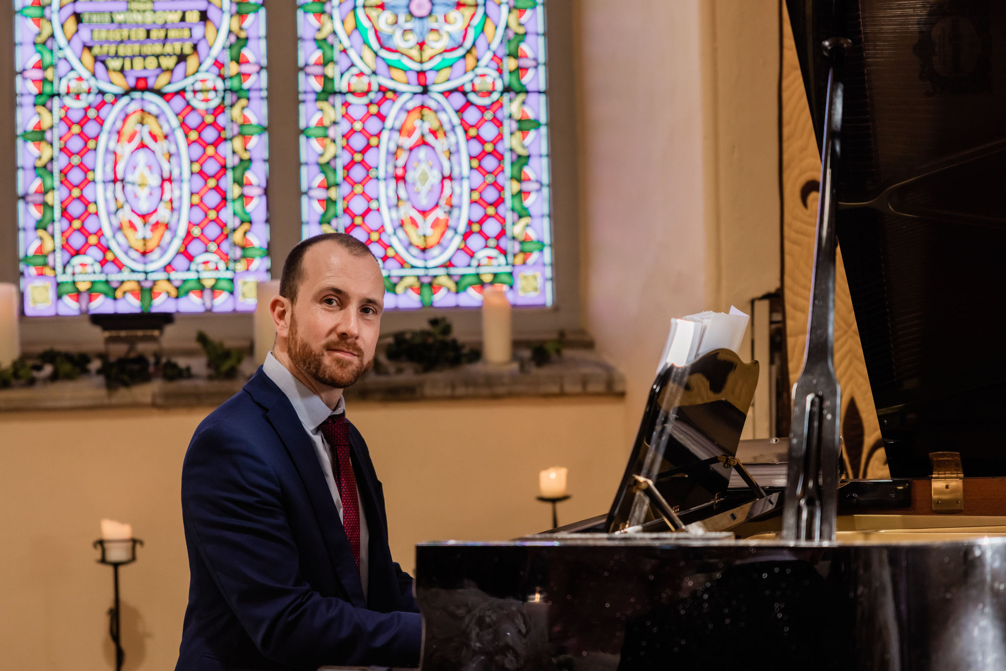 Joe Kenny pianist playing on the grand piano at a wedding ceremony in Carlingford Heritage Centre, Co. Louth